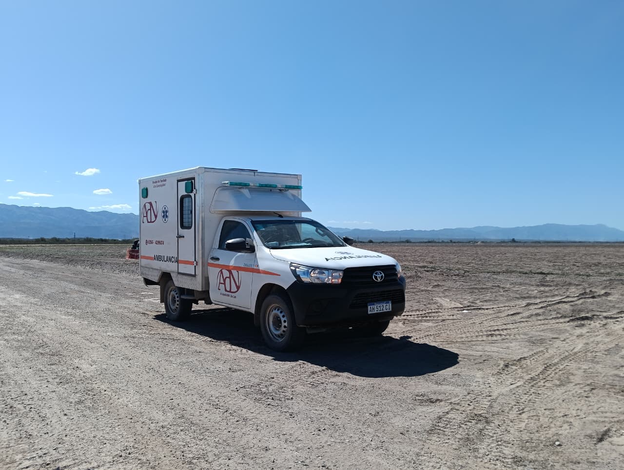 Ambulancia 4x4 de ADN en un camino rural con montañas de fondo